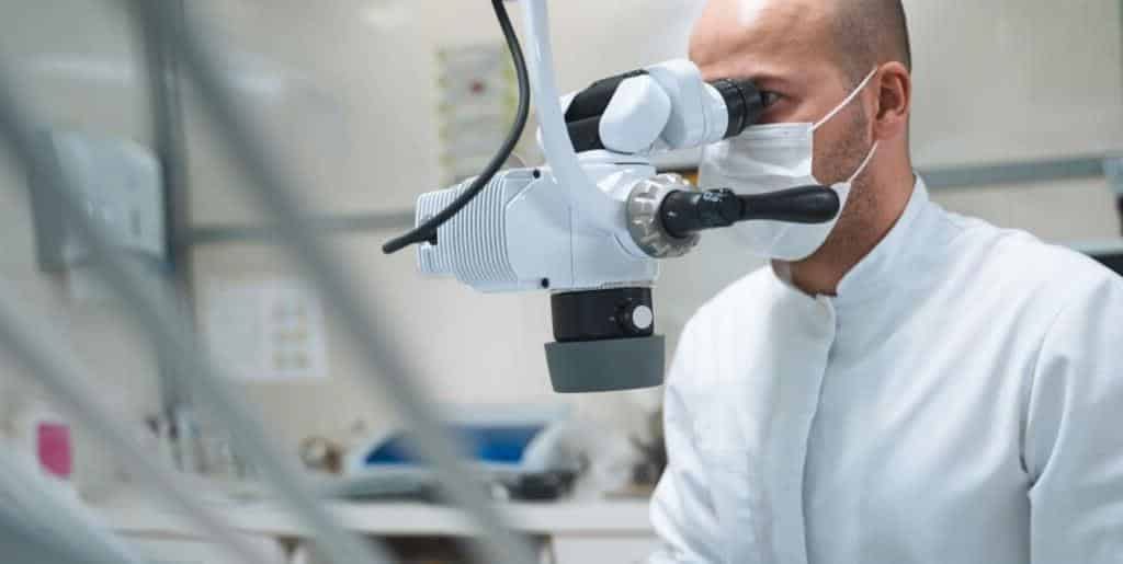 A dentist looking through a dental microscope