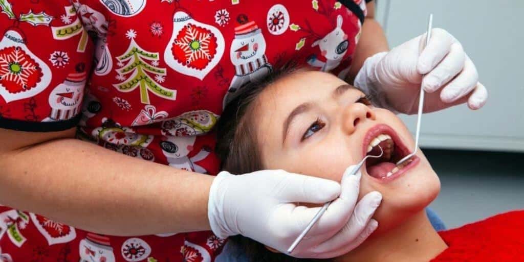 A child having a dental examination beside a festive uniform