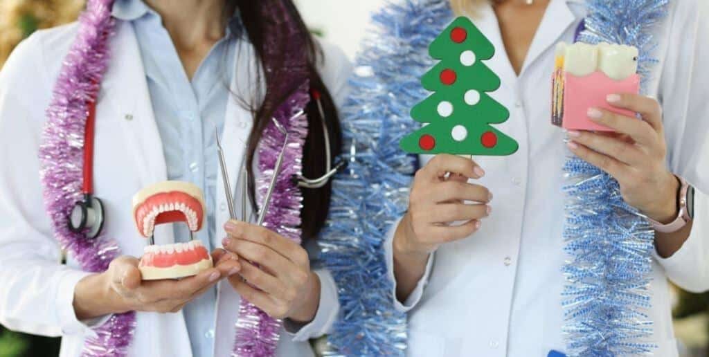 Dental models and Christmas decorations held by people in white coats