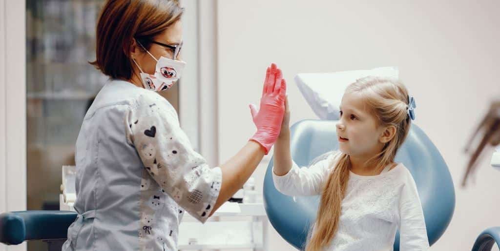 A clinician and child giving each other a high five
