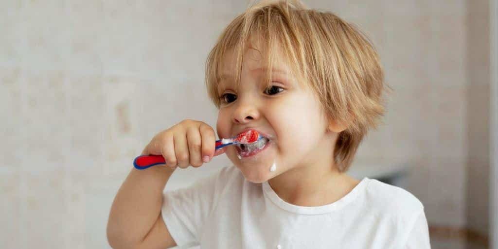 A young child brushing his teeth