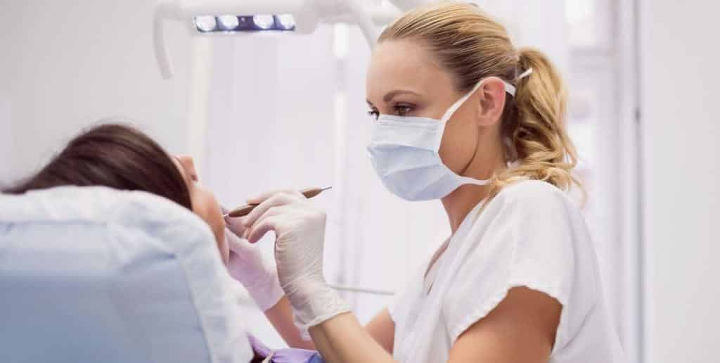 A clinician examining a patient’s mouth