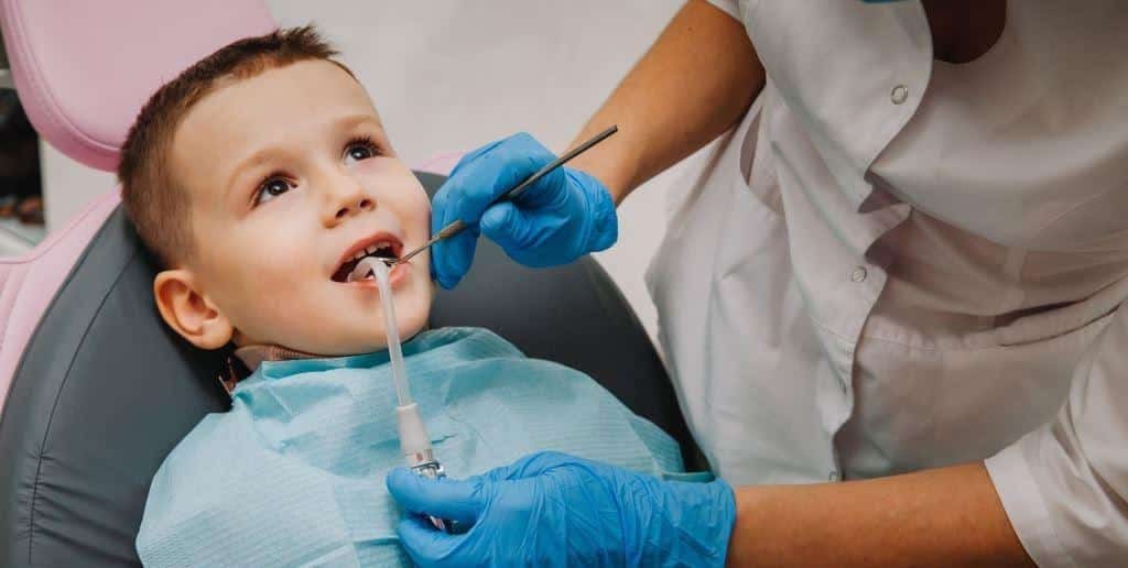 A child having their teeth examined in a dental chair
