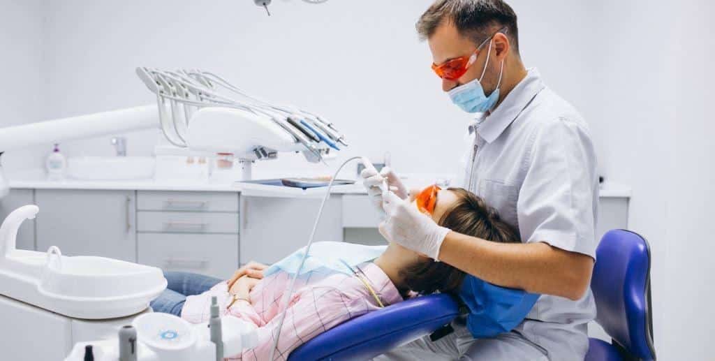 A patient wearing orange protective glasses during dental treatment