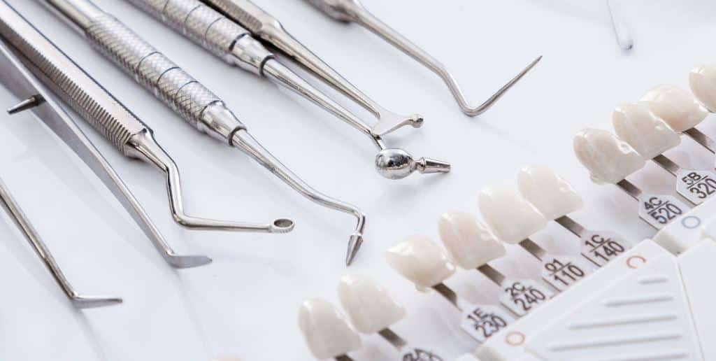 A tooth shade guide beside dental instruments