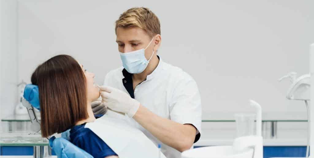 A clinician examining a patient’s teeth