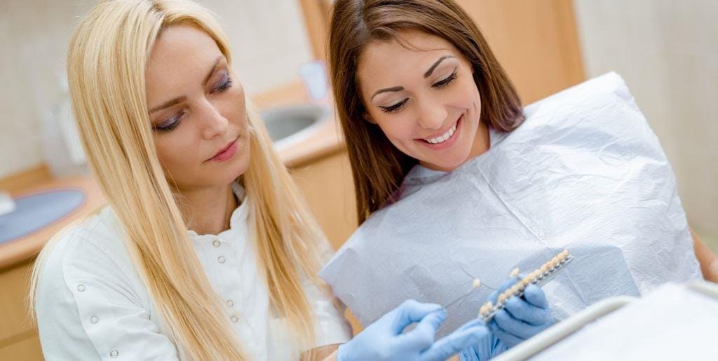 A patient and clinician looking at a tooth shade guide