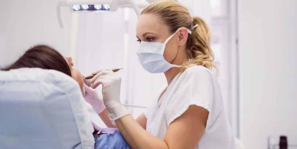A dentist examining a patient in a dental chair