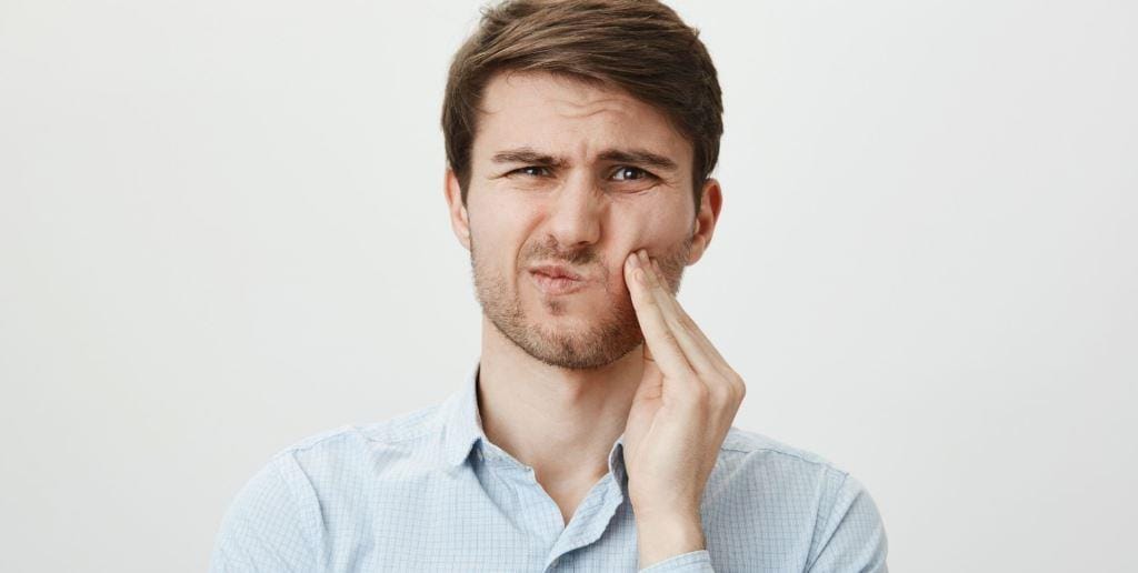 A person pressing a hand against their cheek
