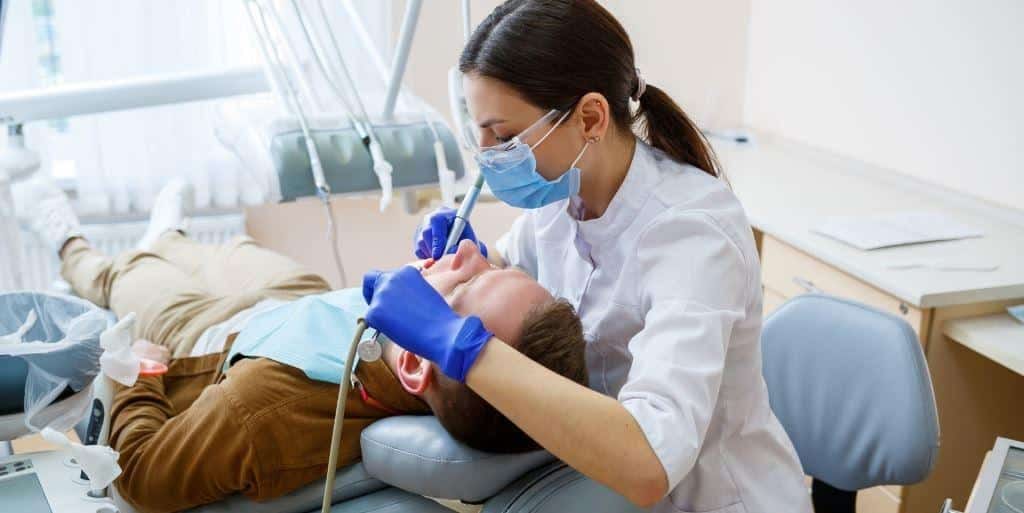 Dental professional examining a patient in a dental chair