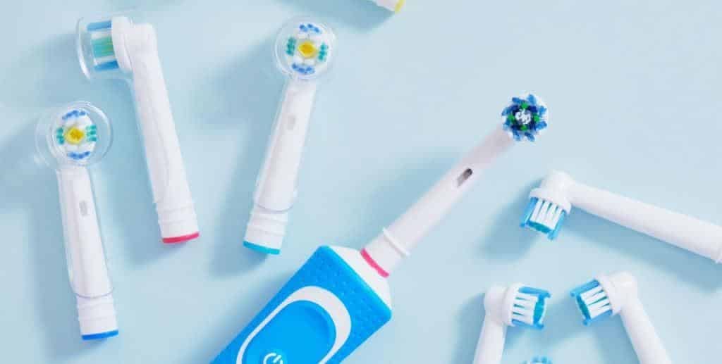 Electric toothbrush heads and dental floss on a blue background