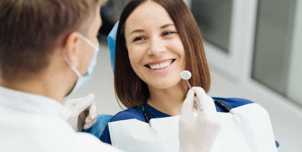 A patient talking with a clinician in a dental chair