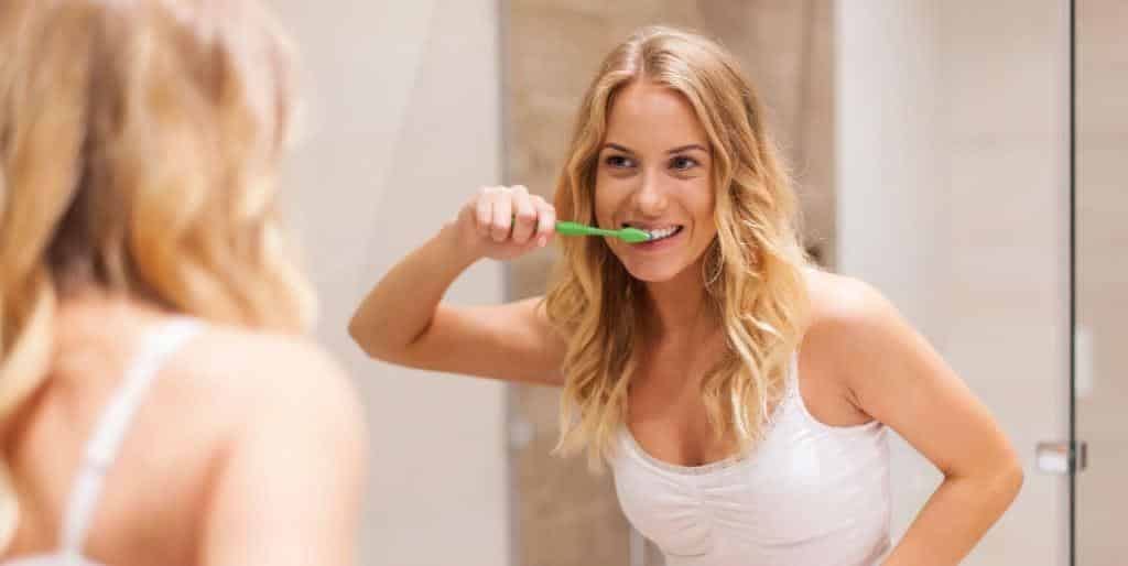A person brushing their teeth in front of a mirror