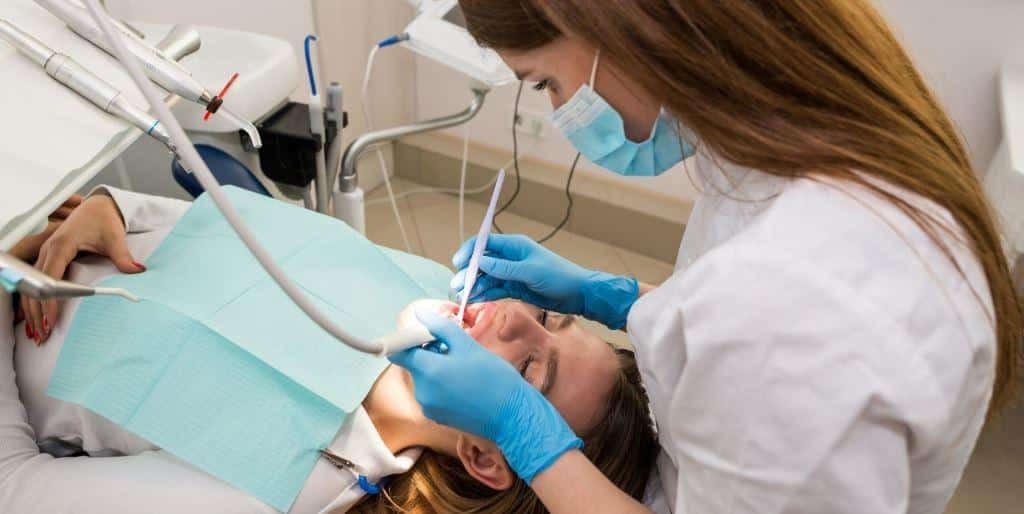 A clinician treating a patient in a dental chair
