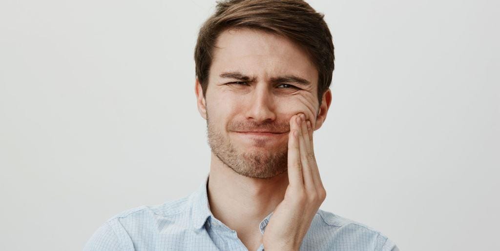 A person holding their cheek