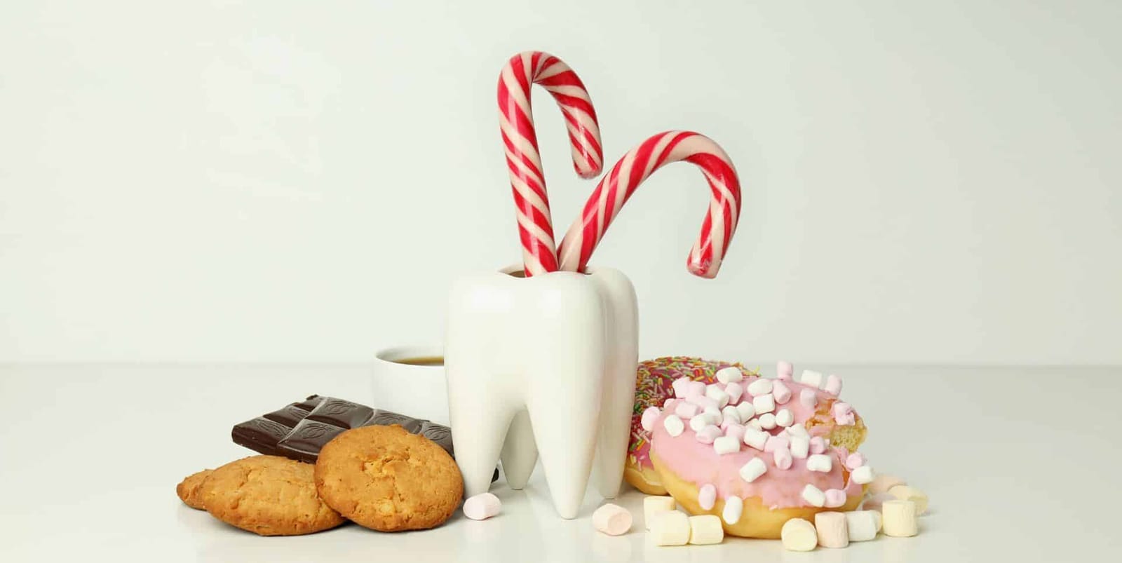 Sweets and biscuits arranged around a model tooth