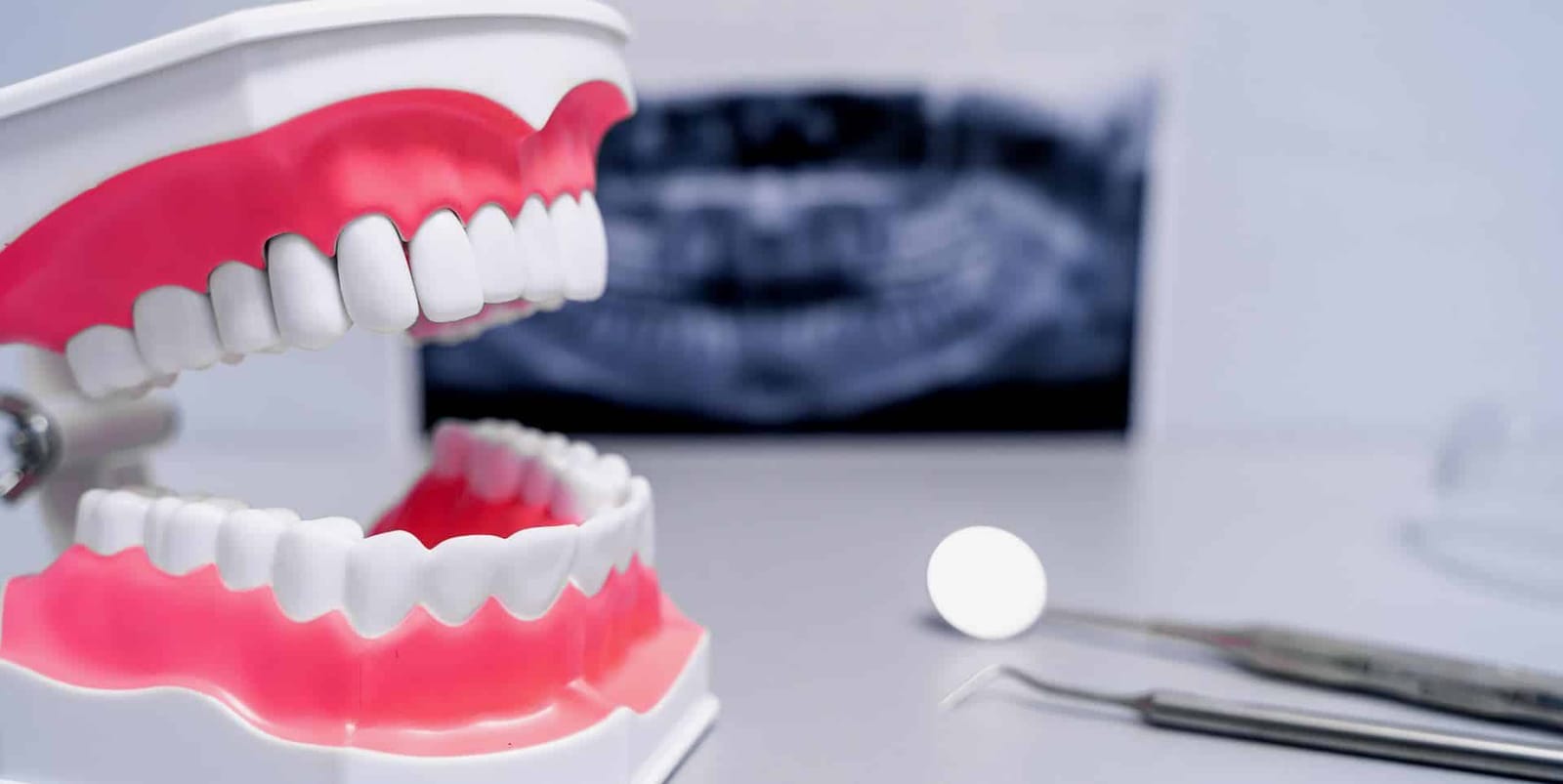 Dental model and instruments with an X-ray in the background