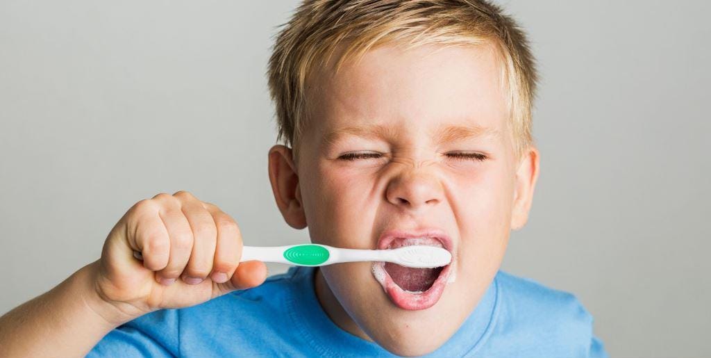 Child brushing their teeth with a toothbrush