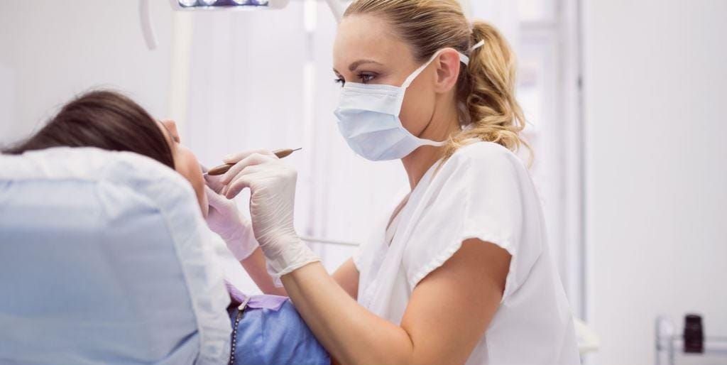 A dental professional examining a patient
