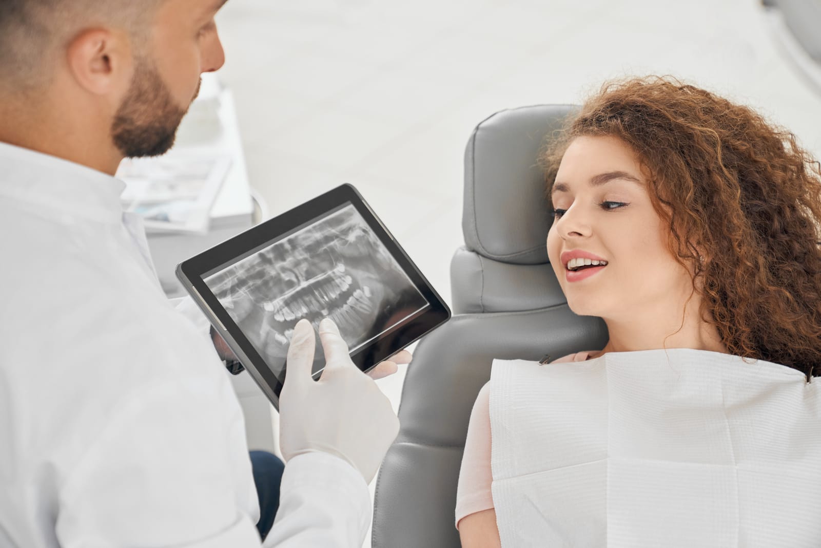 A dentist discussing a dental X-ray with a patient