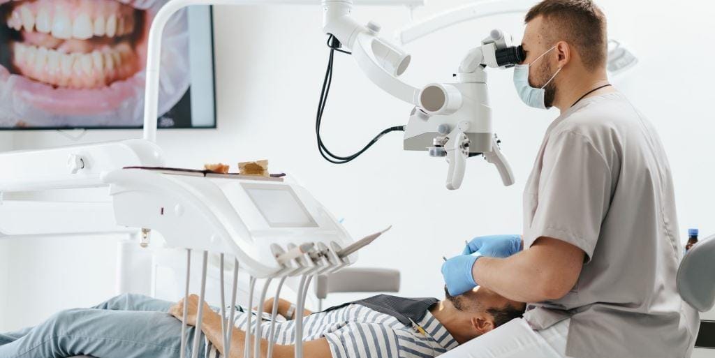 Dentist working with a dental microscope