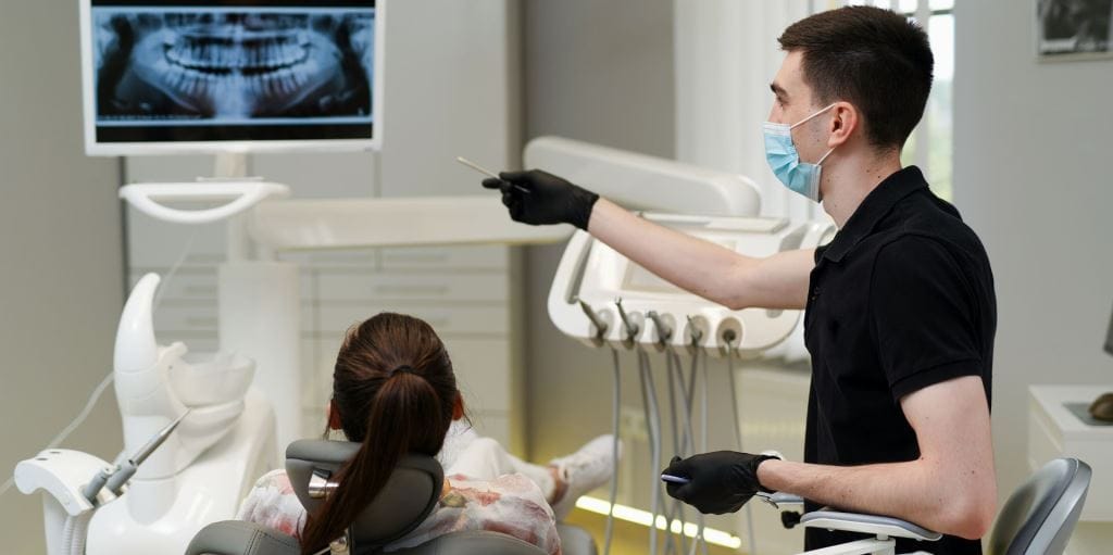 A patient and clinician looking at a dental X-ray