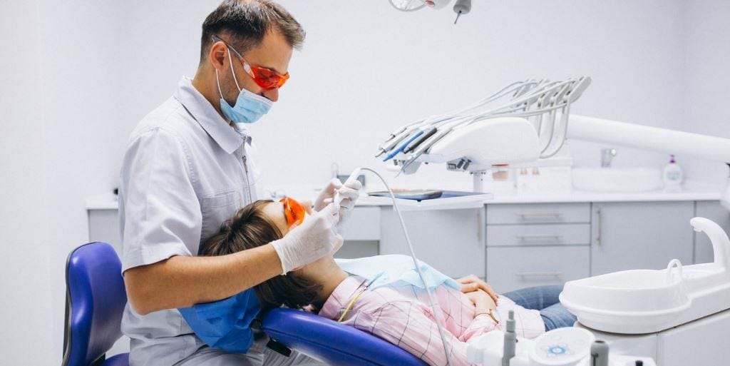 A clinician examining a patient wearing protective glasses