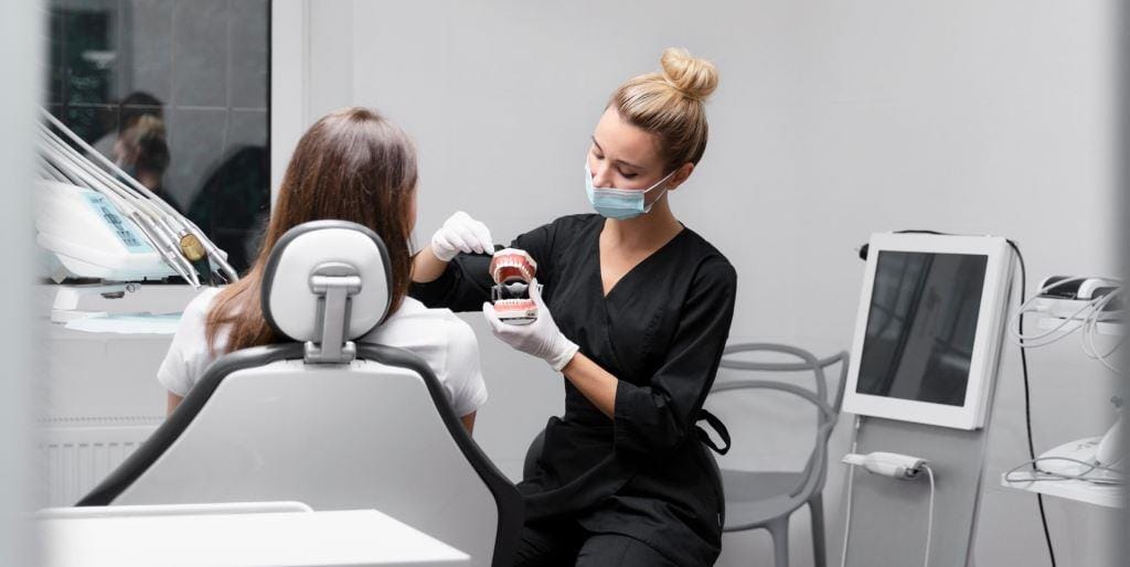 A clinician discussing a model of teeth with a patient