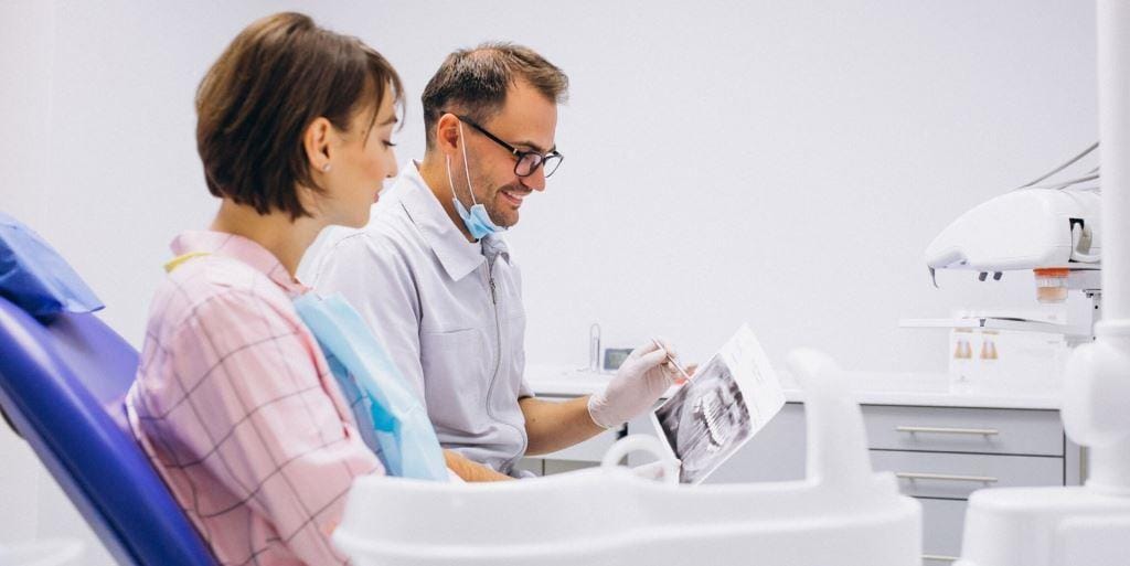 A clinician and patient looking at a dental X-ray