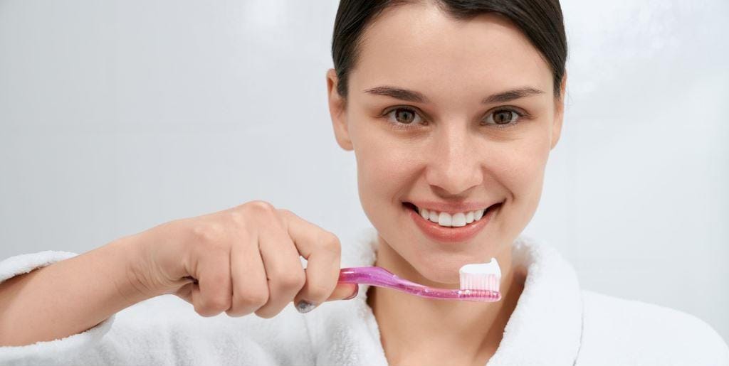 A person holding a toothbrush with toothpaste