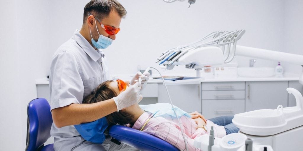 A clinician treating a patient in a dental chair