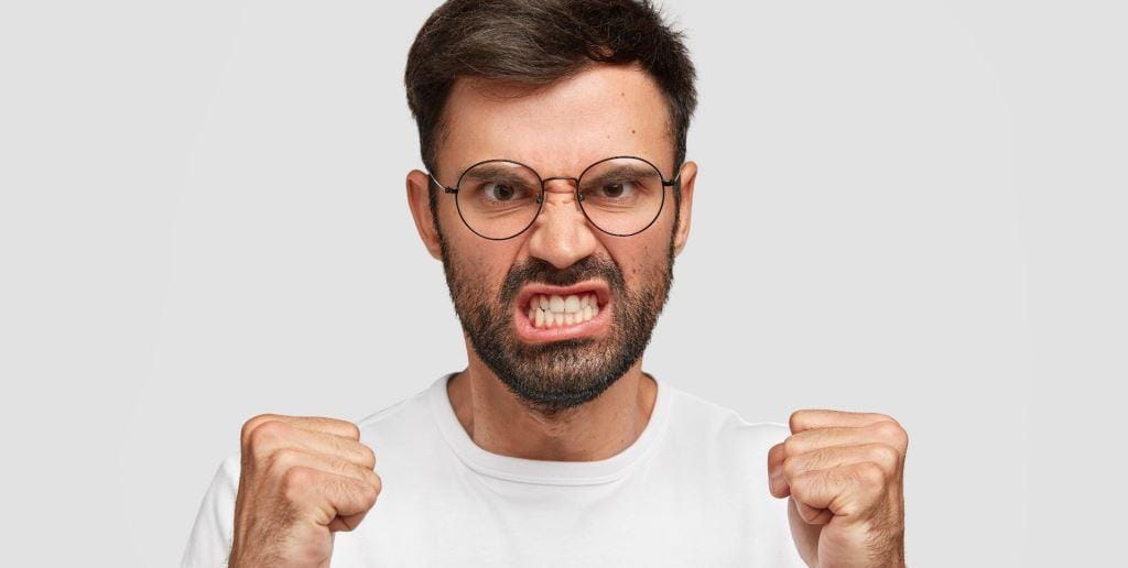 A man clenching his teeth and fists