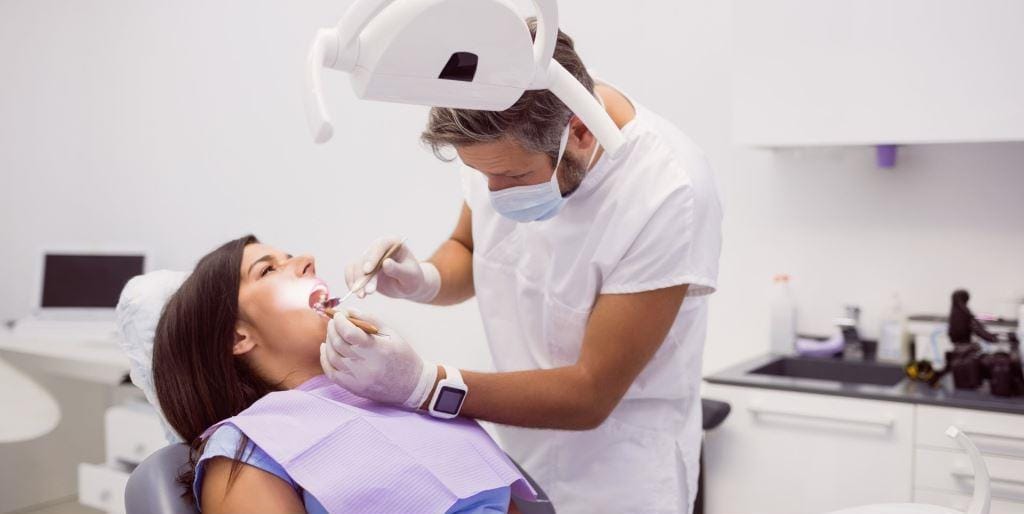 A dentist examining a patient in a dental chair