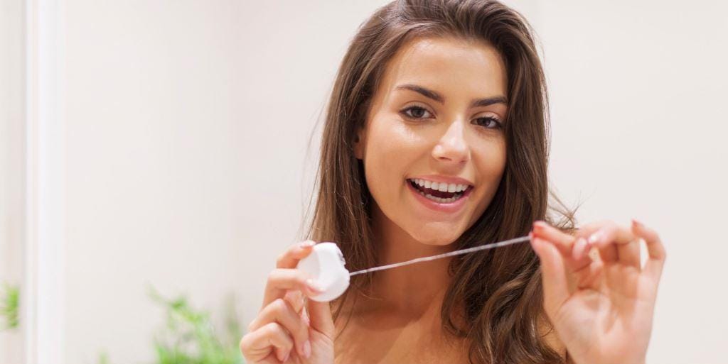 Woman holding dental floss between her hands