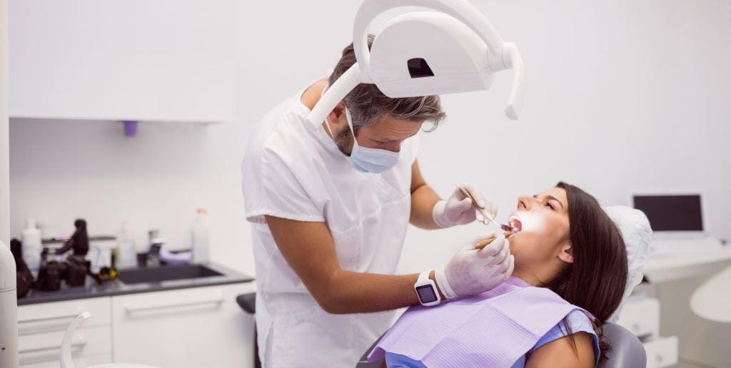 A dentist treating a patient in a dental chair