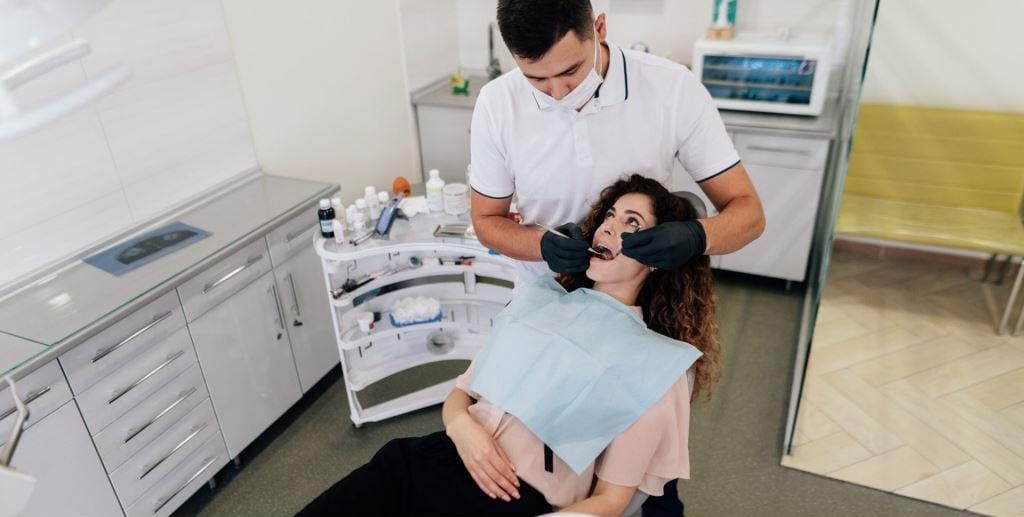 A dentist examining a patient in a treatment room