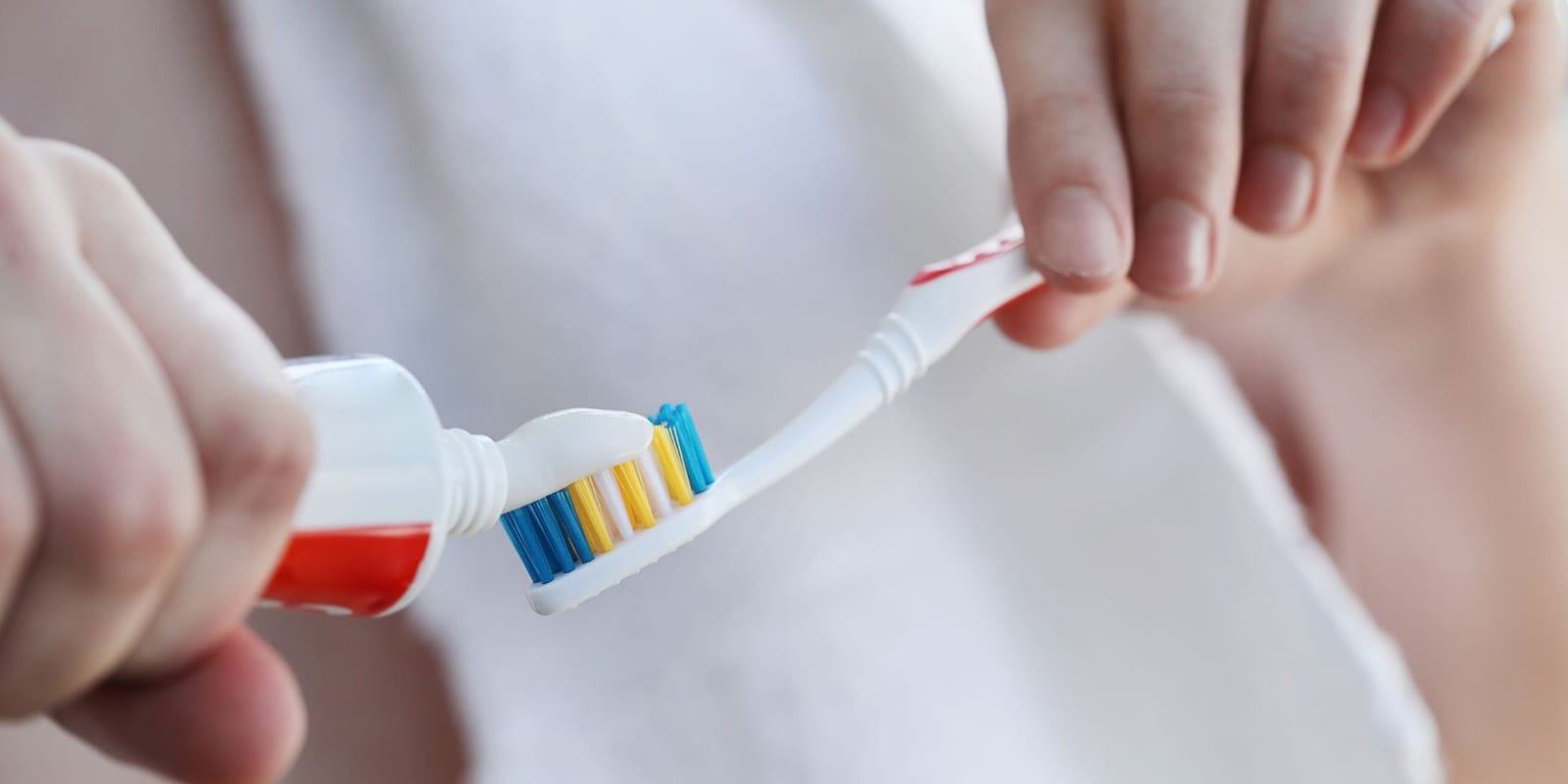 Toothpaste being placed on a toothbrush