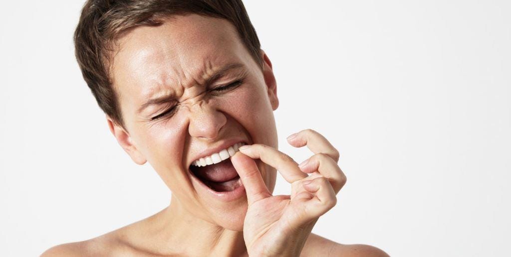 A woman pulling down her lower lip with a finger