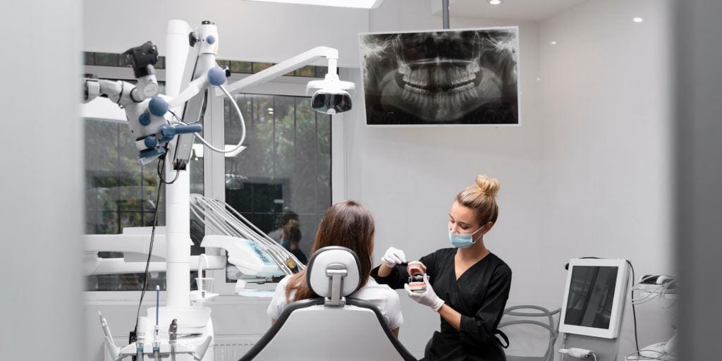 A dental professional showing a model to a patient