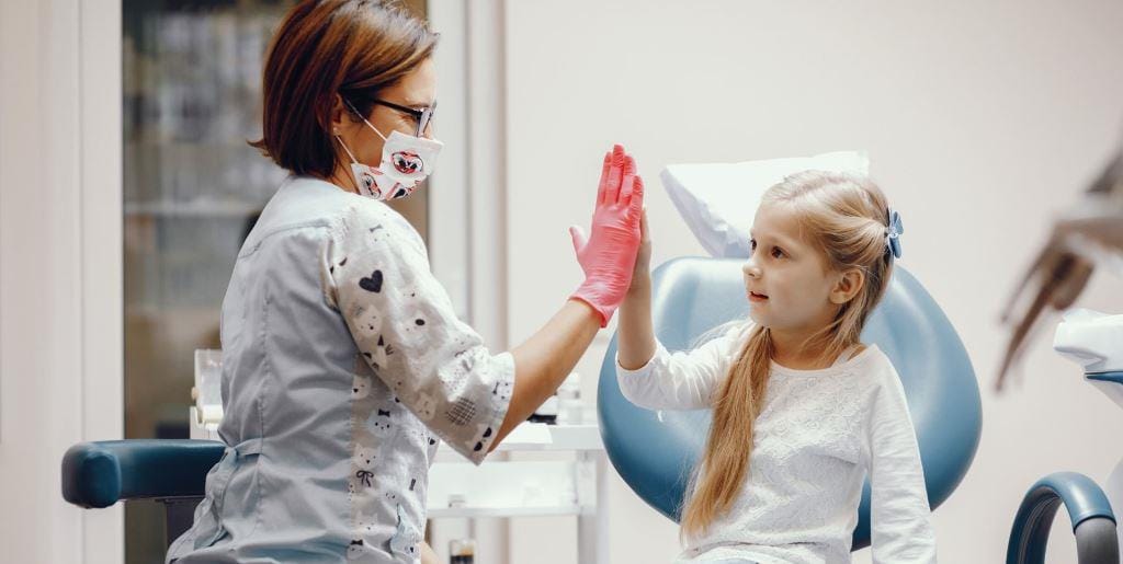 Child giving a dental professional a high five