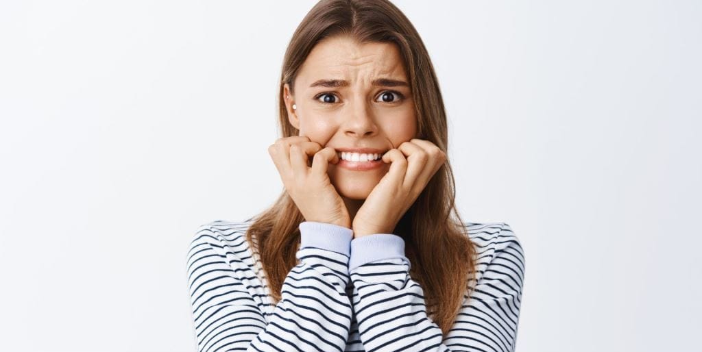 A woman biting a fingernail