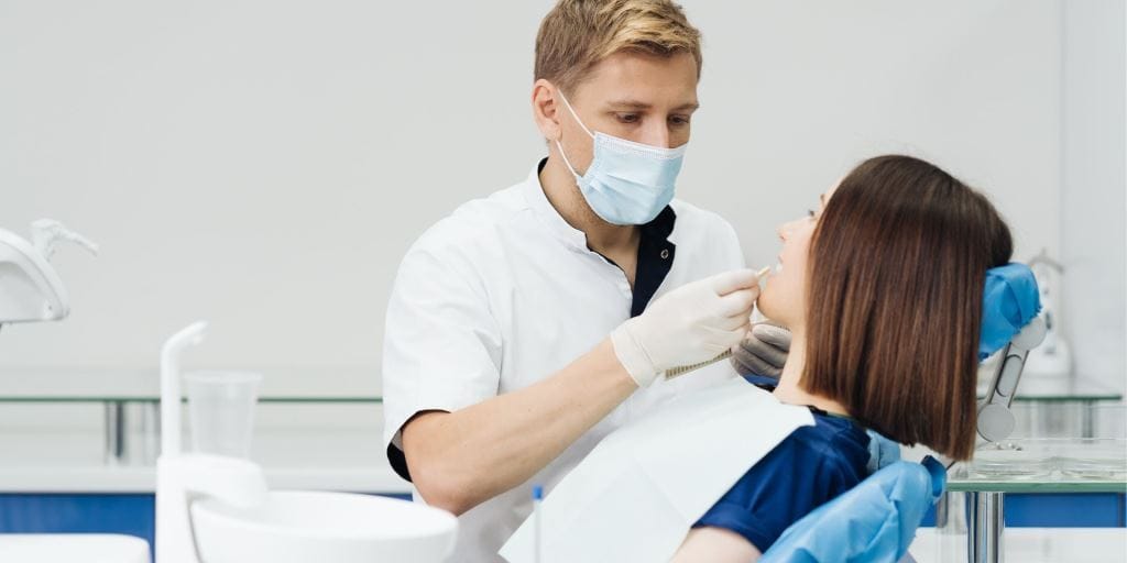 A dentist examining a patient in a dental chair