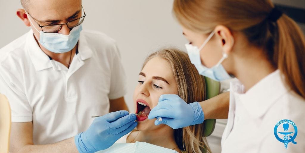 Two members of a dental team examining a patient