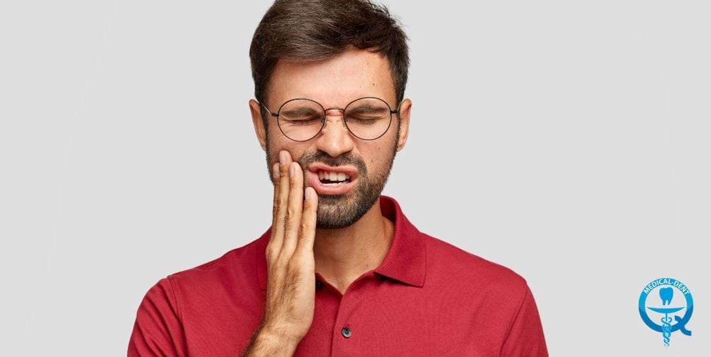 Man holding his cheek with an expression of pain
