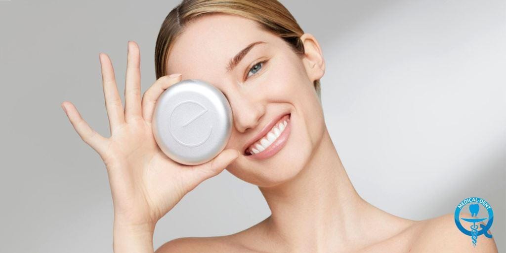 A woman holding a round tray case over one eye