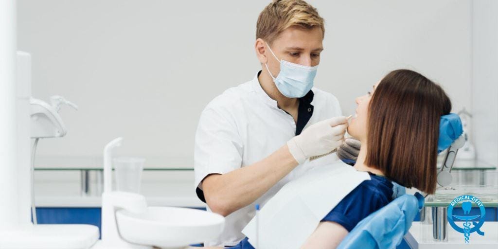 A clinician examining a patient in a dental chair