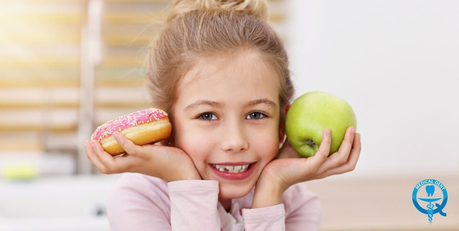 A child holding an apple and a doughnut