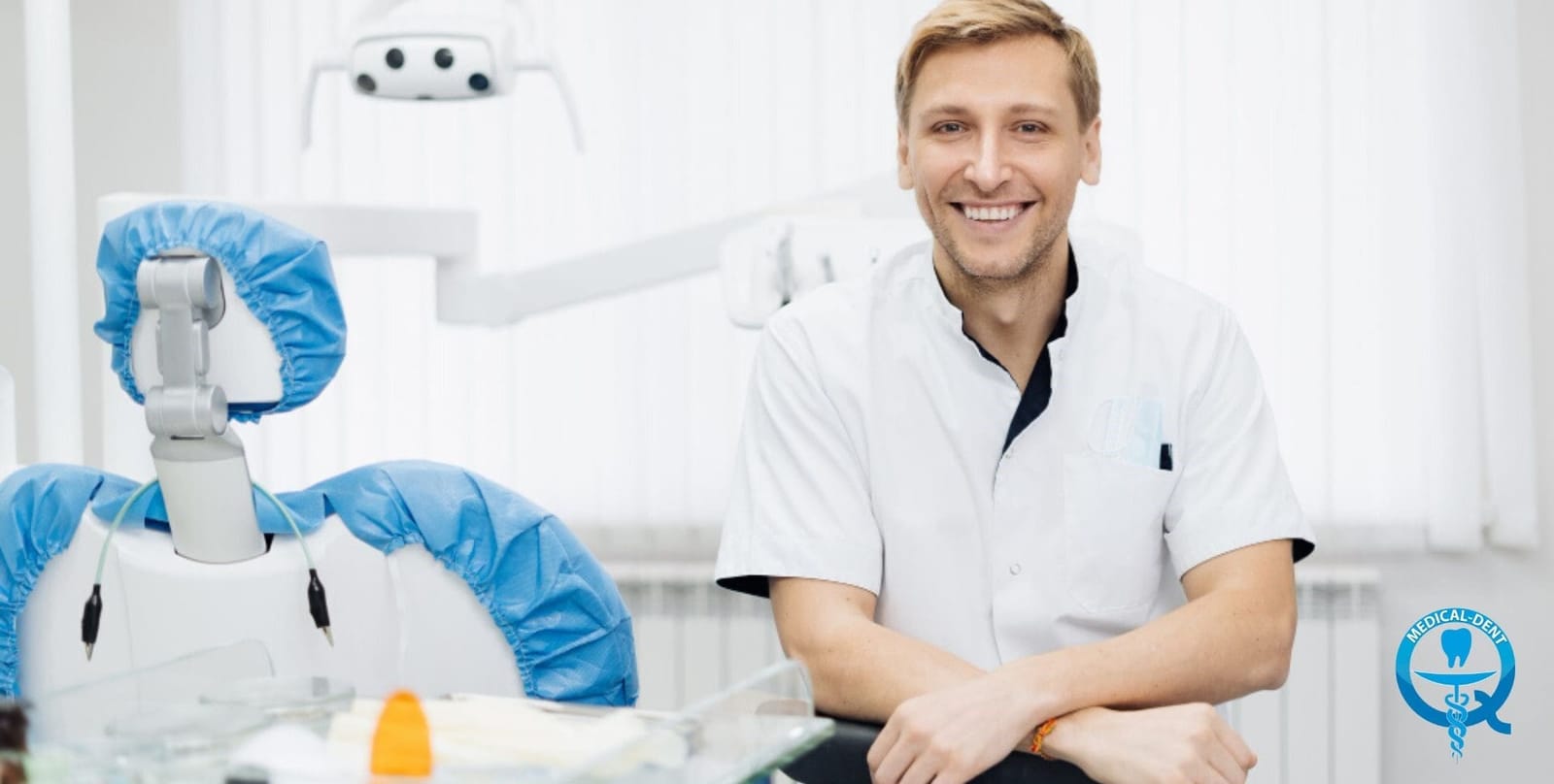 A dental professional seated beside a dental chair