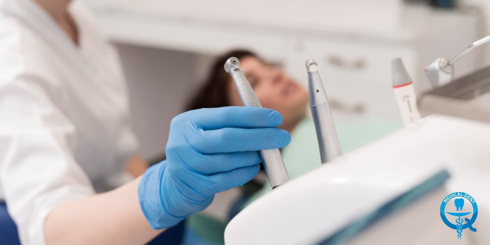 A gloved hand holding a dental instrument beside a patient