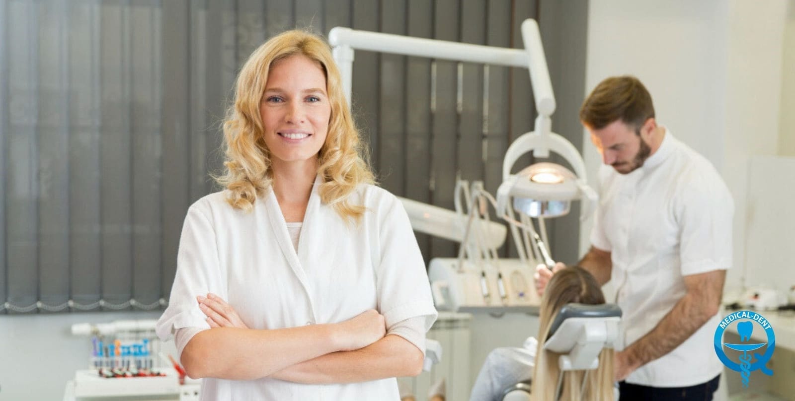 A dental team member in a white gown with a colleague in the background